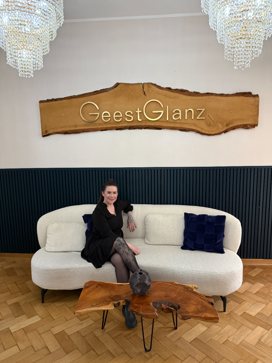 Nathalie auf der Lounge-Couch unter dem GeestGlanz-Schild